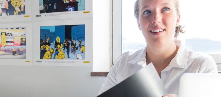 Branded entertainment student working at desk with design concepts