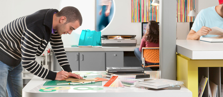 Graphic design student working Graphic design student using cutting mat in Adler Hall