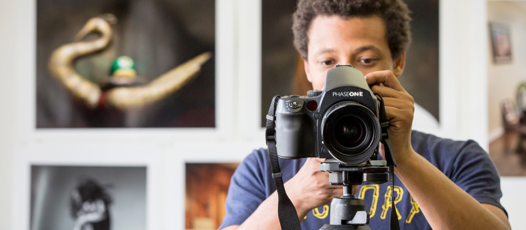 Photography student adjusting camera Photography student in studio looking at viewfinder