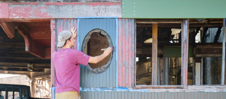 Preservation design students painting train car