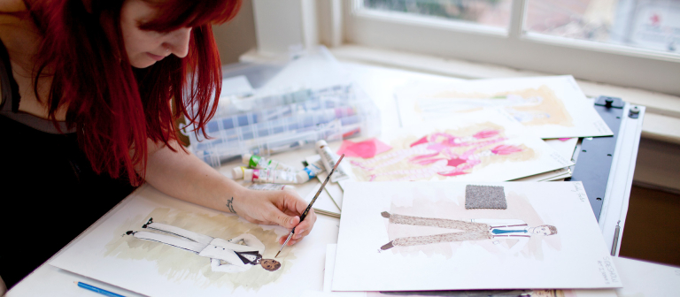 Production design student using watercolors to create costume designs