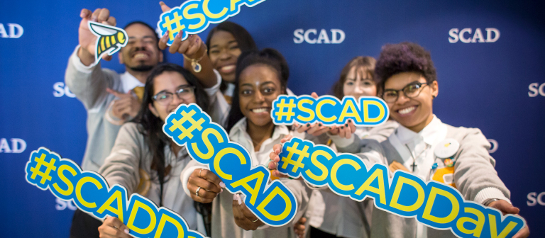 Exuberant students hold #SCAD signs