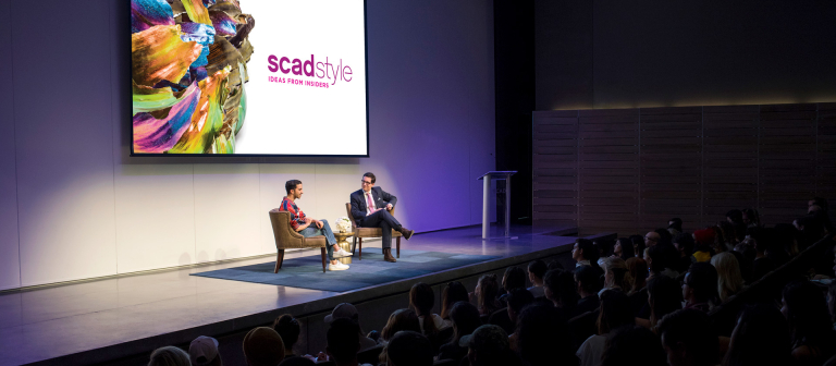 Two men sit on stage for SCAD style