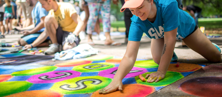Woman draws with chalk at SCAD Sidewalk Festival