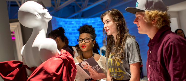 Students enjoying SCAD FASH reception SCAD Atlanta students admiring garment at SCAD FASH reception