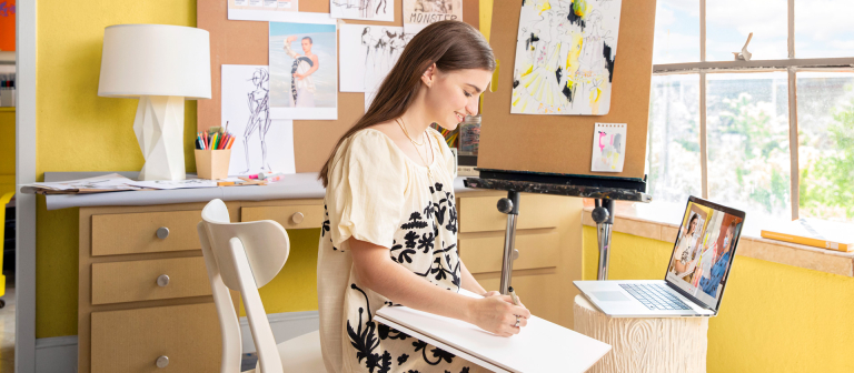 Fashion student sketching in room
