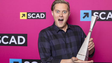 Lucas Grabeel holding trophy