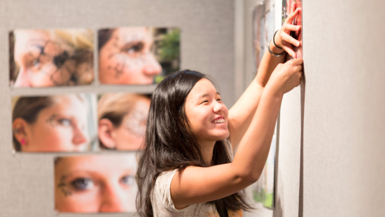 Summer programs student hanging photography prints for critique Summer programs student hanging photography prints for critique