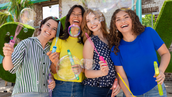 Four SCAD Savannah Rising Star students smiling making bubbles