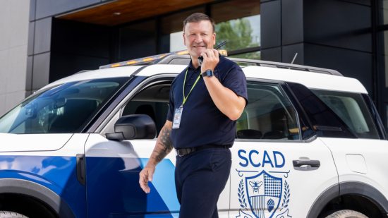 SCAD University security in front of vehicle.
