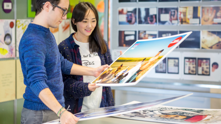 Advertising students looking at print designs