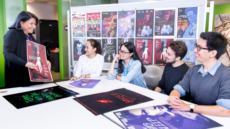 SCAD professor of advertising showing movie posters to students