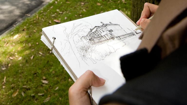 Architectural history student drawing building on sketchpad