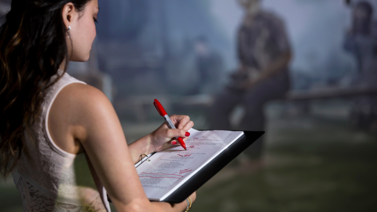 Dramatic writing student editing script on set of play
