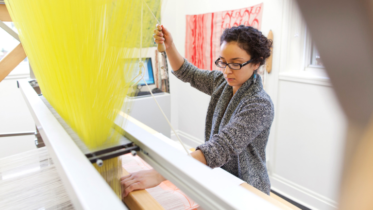 Fibers student weaving on Jacquard loom Fibers student weaving on Jacquard loom
