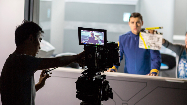 Film and television students syncing shot with clapperboard