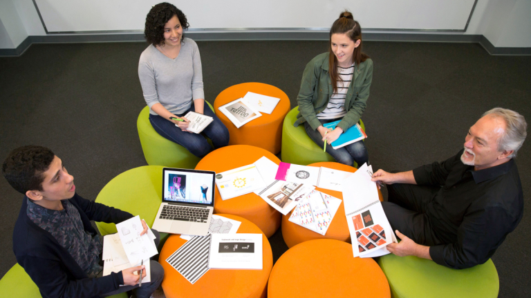 SCAD graphic design students critiquing with Steff Geissbuhler 