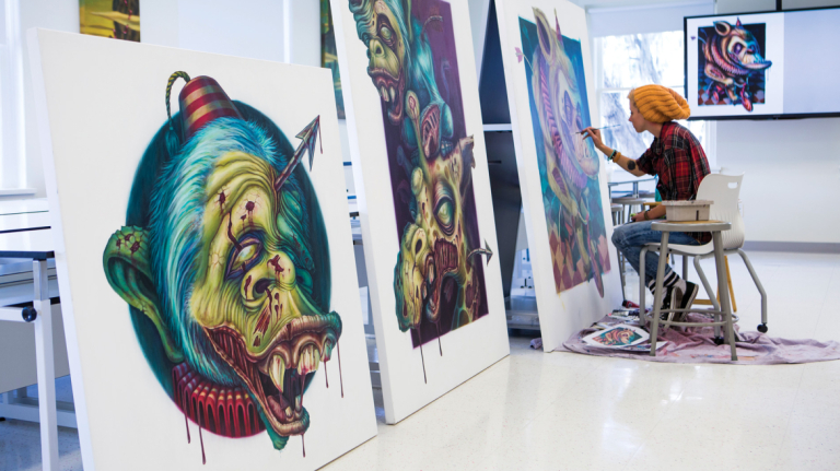 Illustration student painting on large canvas in Haymans Hall