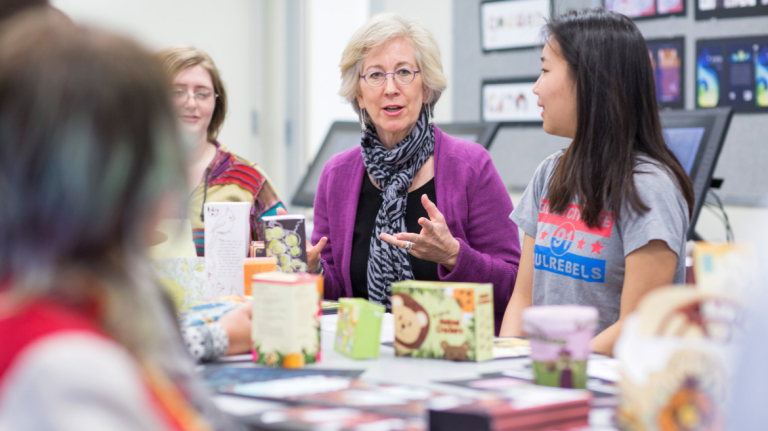 Illustration professor discussing designs with students
