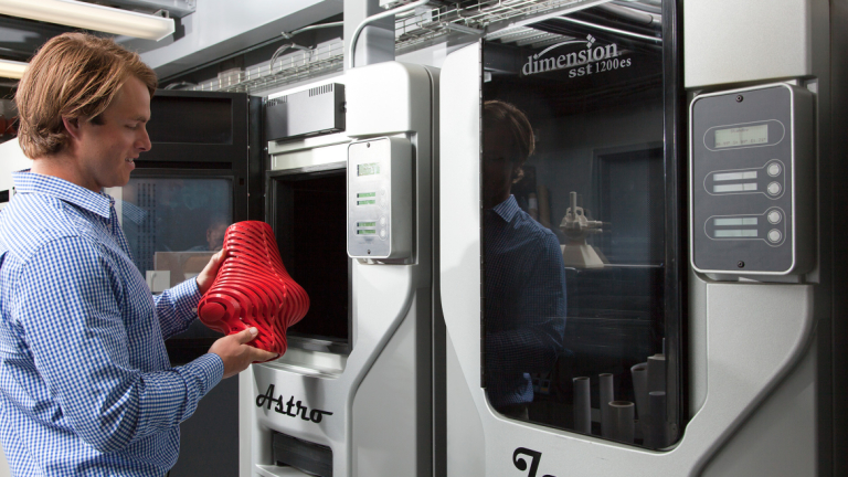 Industrial design student creating prototype with 3D printer