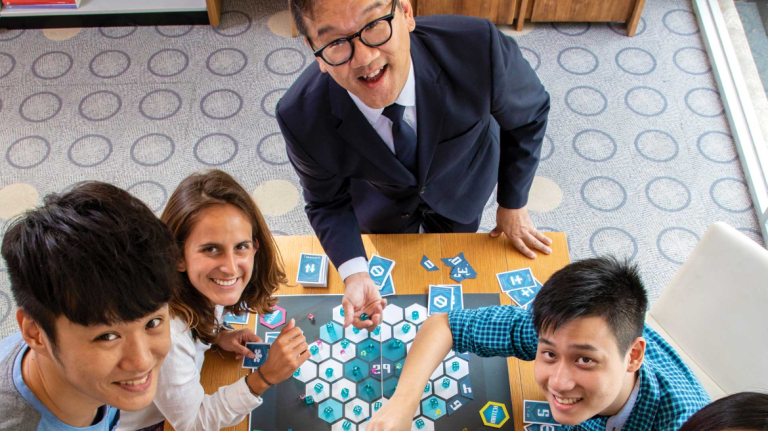 Interactive design and game development professor and students explore a board game