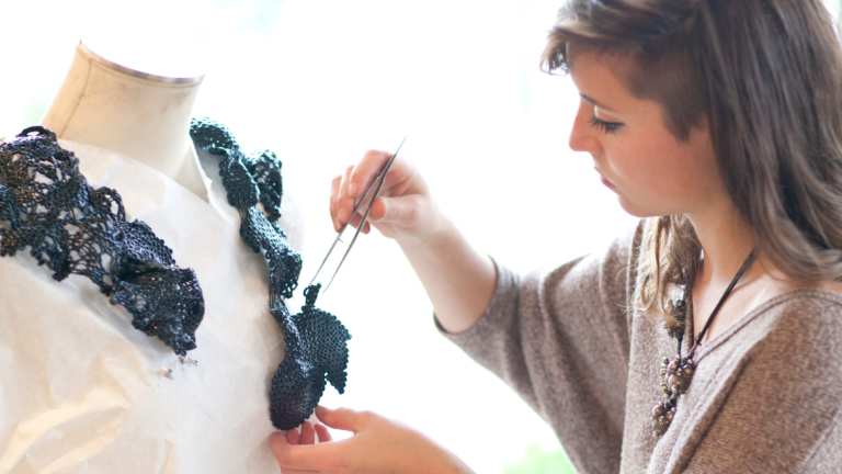 Jewelry student fabricating a design Jewelry student crafting a design on mannequin