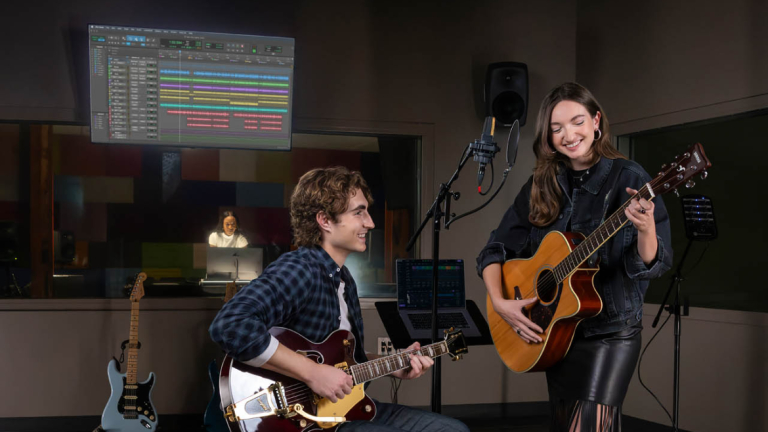 Two students on guitar in recording room.
