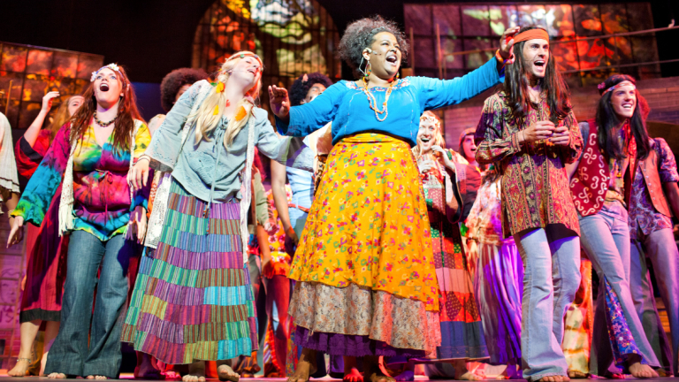Performing arts students singing on stage Performing arts students singing in production of Hair