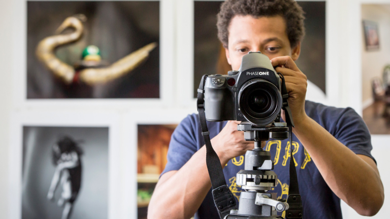 Photography student adjusting camera Photography student in studio looking at viewfinder