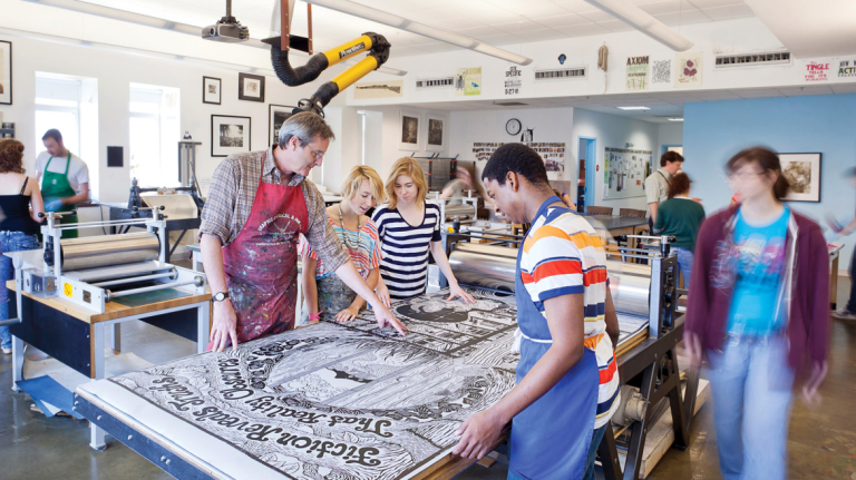 Printmaking professor and students examining large print on press