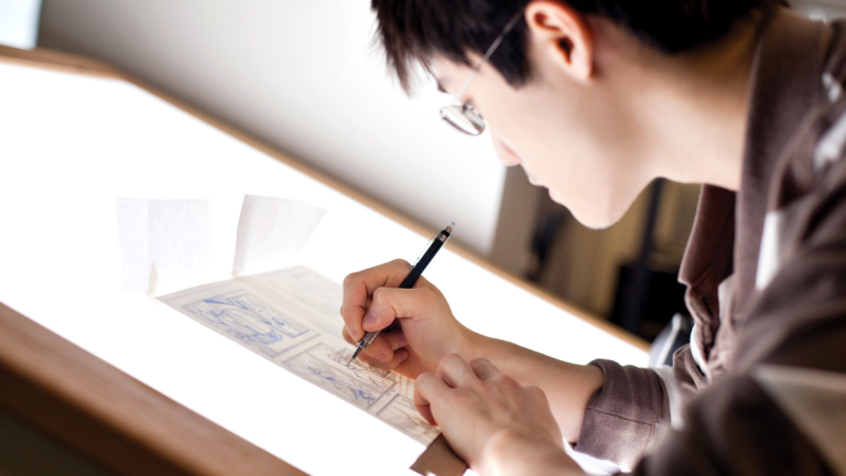SCAD student drawing at light table