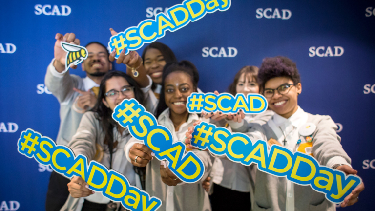 Exuberant students hold #SCAD signs