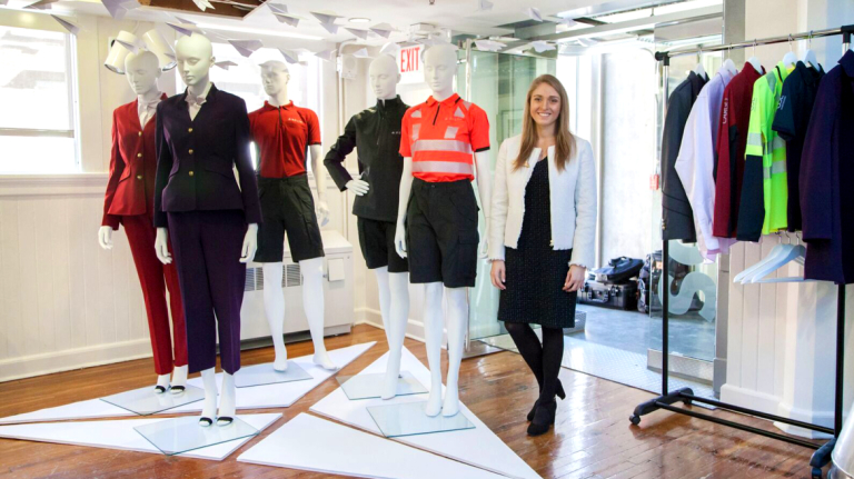 Student who participated in a SCADpro project stands with Delta Air Lines uniforms 