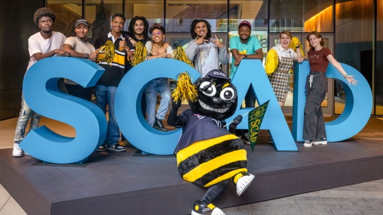SCAD bee at an event cheering.