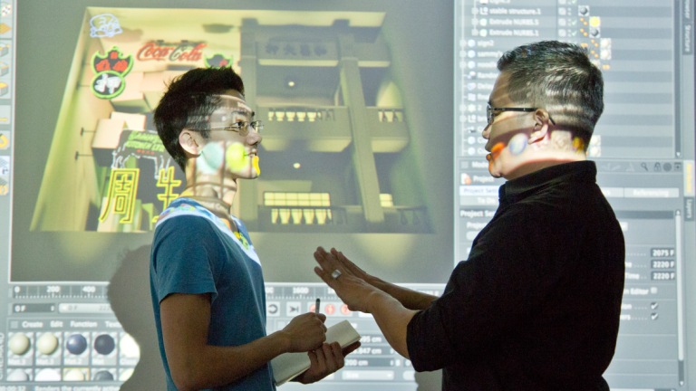 Motion media professor working with student Motion media student and professor discussing work on projection screen