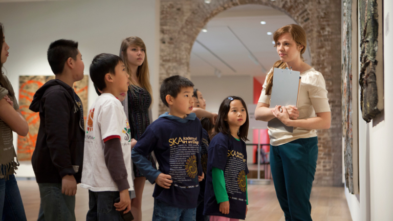 SCAD Museum of Art staff member leading tour SCAD Museum of Art staff member giving tour to school children