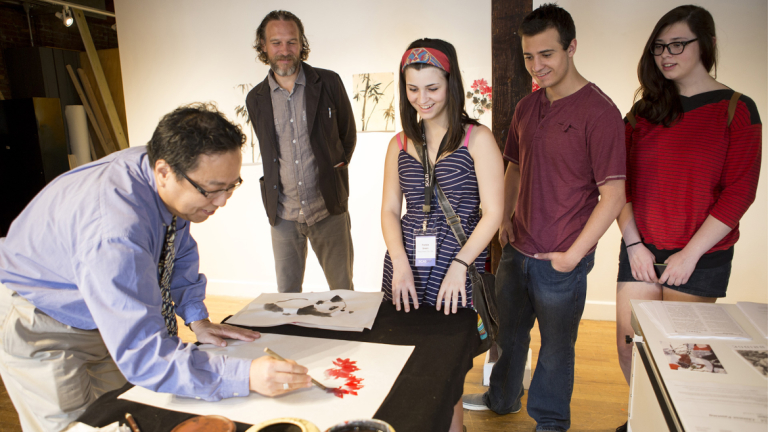 A SCAD professor demonstrates a painting technique during SCAD Day