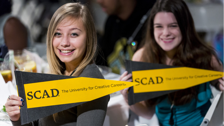 SCAD students with pennants
