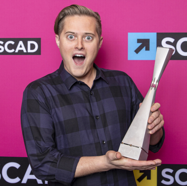 Lucas Grabeel holding trophy