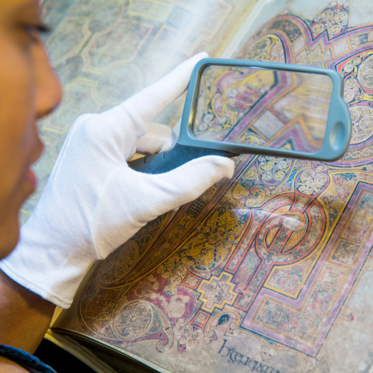 Art history student using magnifying glass