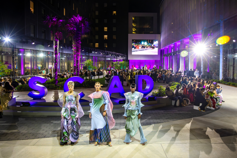 SCAD Fashion Show 2023 models watching a runway in Atlanta at night.
