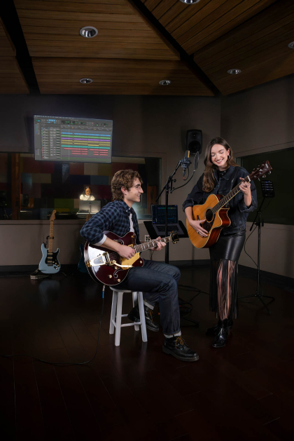 Two students on guitar in recording room.