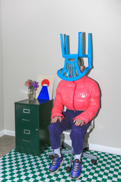 Photography student work by Shan Shi with person sitting in pink jacket and blue chair on head
